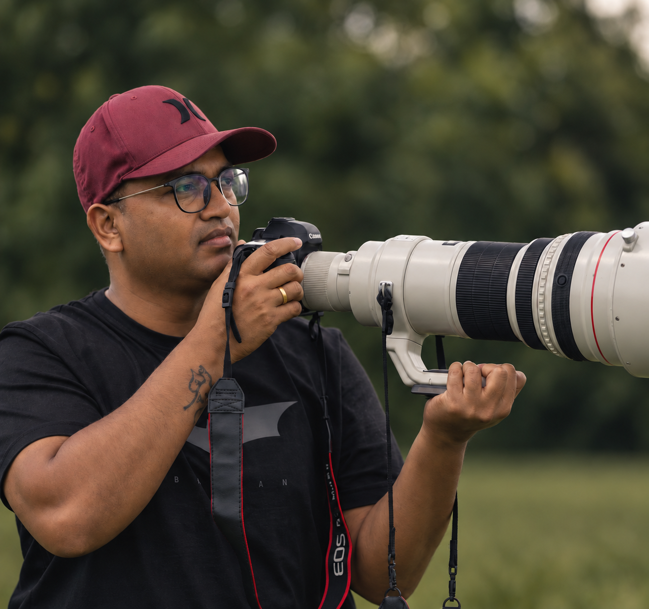Wildlife photographer Ramakanth looking through his long Canon telephoto lens
